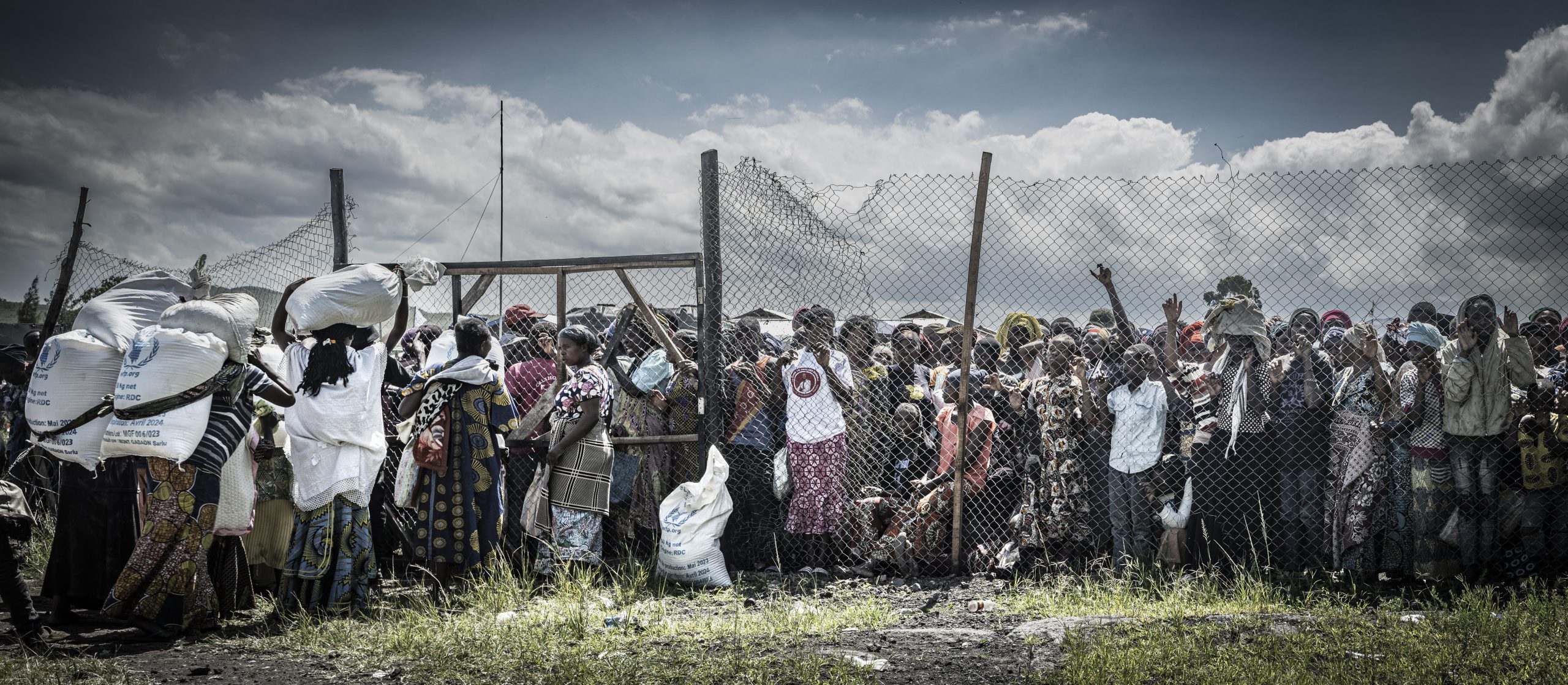 People queue for practically non-existent WFP food deliveries. Lushagala IDP camp.